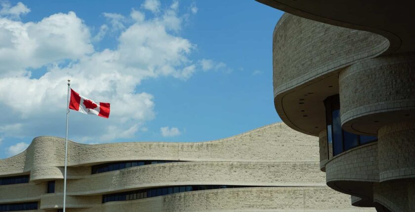 Canadian flag flying above buildings.